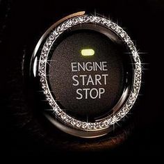 an engine start button with the words stop written in white letters on it, surrounded by sparkles