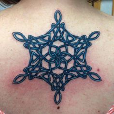 the back of a woman's shoulder with an intricate tattoo design on her chest