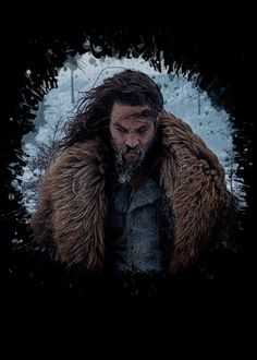 a man with long hair and beard wearing a fur coat in front of snow covered trees