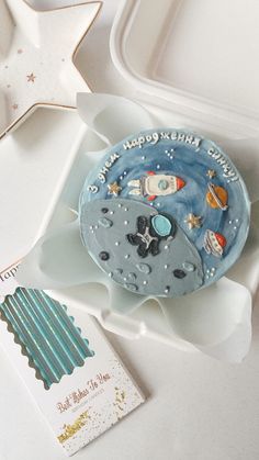 a cake in the shape of an astronaut's moon on a tray with other items