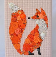 an orange and white animal made out of buttons on a piece of paper with beads