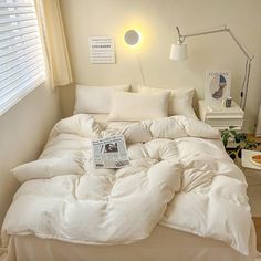 an unmade bed in a bedroom with white sheets and pillows on top of it