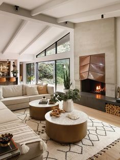 a living room with couches, tables and a fire place in the fireplace area