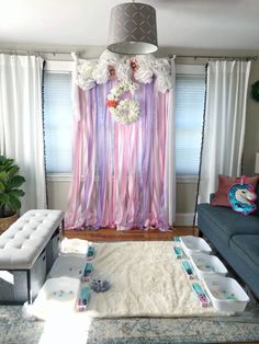 a living room decorated in pastel colors with curtains and flowers on the back wall