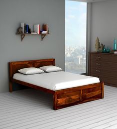 a bed sitting on top of a white floor next to a wooden dresser under a window