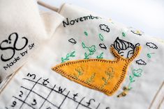 a close up of a piece of cloth with embroidered designs on it and the words november written in cursive writing