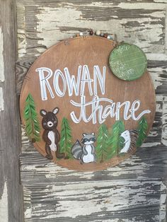 a wooden sign that says rowan theatre with raccoons and bears on it's side