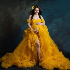 a pregnant woman in a yellow gown posing for a photo