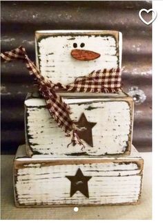 three wooden boxes with snowmen and stars painted on the top one has a bow