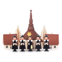 a group of figurines are standing in front of a small church with a star on top