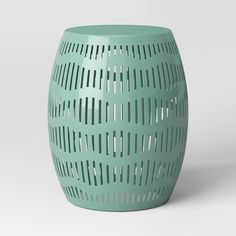 a green vase with holes in the middle