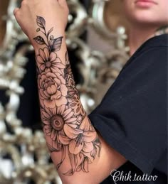 a woman is holding her arm with flowers on it