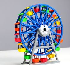 a toy ferris wheel with many colors on it's rim and wheels in the center