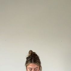 a woman sitting at a table with a plate of food in front of her and looking down