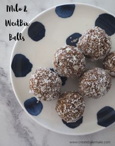 a white plate topped with chocolate balls covered in powdered sugar