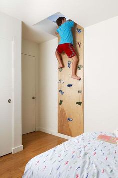 a man climbing up the side of a wall on top of a wooden board in a bedroom