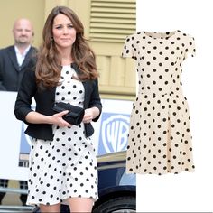 a woman in a polka dot dress and black blazer is standing next to a car