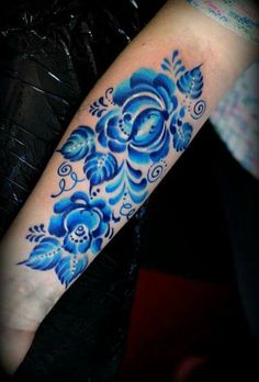 a blue flower tattoo on the arm