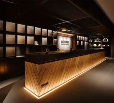 the front desk of a shoe store is lit up with dim lighting and wood paneling