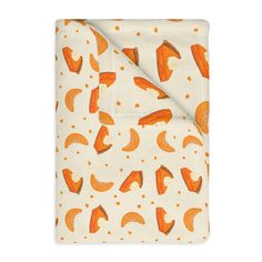 an orange and white blanket on top of a white sheet with polka dot dots in the background