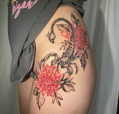 a woman's thigh with flowers on it and the word dragon written in cursive writing