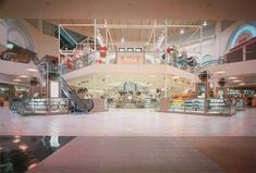 an empty shopping mall with escalators and stairs