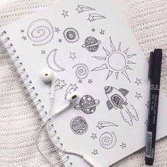 an open notebook with space drawings on it