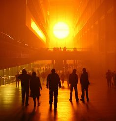 many people are walking around in the foggy city at sunset or sunrise, and there is only one person on the sidewalk