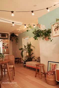 a living room filled with furniture and lots of plants on the wall next to it