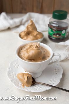 two cups filled with peanut butter on top of a white saucer