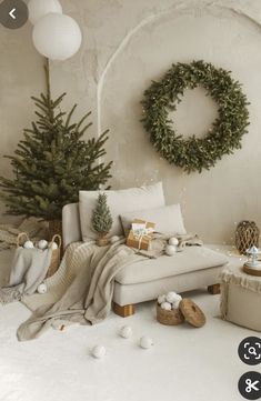 a living room filled with furniture and a christmas tree in front of a wreath on the wall