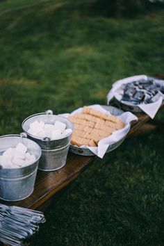 two buckets filled with marshmallows sitting on top of a wooden table