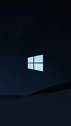 the windows logo is lit up in the dark sky above a desert landscape at night