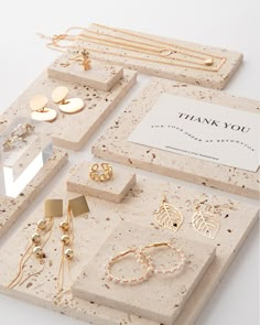 a table topped with lots of different types of earrings and necklaces on top of each other