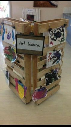 an art gallery made out of wooden pallets with pictures on them and a sign that says art gallery