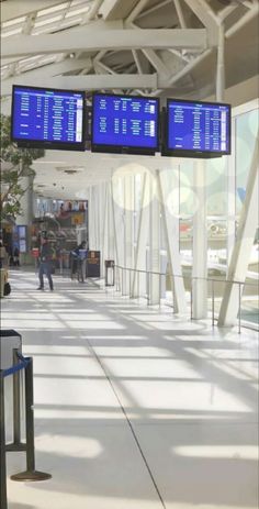 an airport terminal with two large blue screens