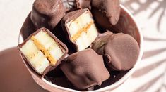 a bowl filled with chocolate covered desserts on top of a table