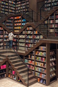 there is a man that is standing on the stairs in front of bookshelves