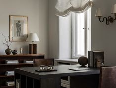 a room with a desk, chair and lamp in it