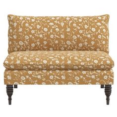 an orange and white floral couch with wooden legs