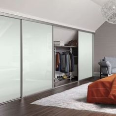 a bedroom with an orange bed and white closets