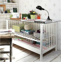 a desk with a lamp on top of it next to a shelf filled with books