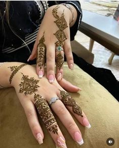 two hands with henna tattoos on them