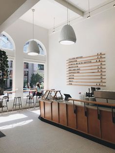 the interior of a coffee shop with tables and stools