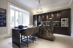 a modern kitchen with marble counter tops and bar stools next to the dining room table