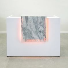 an abstract sculpture with white and grey marble in the center, surrounded by neon lights