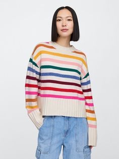 a woman wearing a multicolored striped sweater