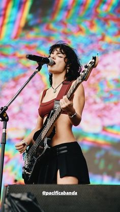 a woman with an electric guitar on stage