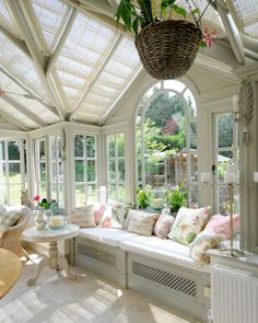 a sun room with lots of windows and furniture