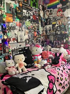 there are many hello kitty stuffed animals on the bed in this room with posters all over the walls